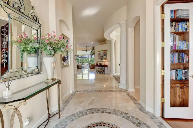 a view of a hallway with wooden floor and a chandelier