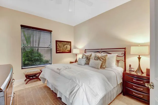 a view of a patio with couches table and chairs under an umbrella with large trees