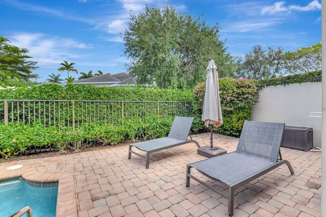 a view of a swimming pool with a chair and palm trees