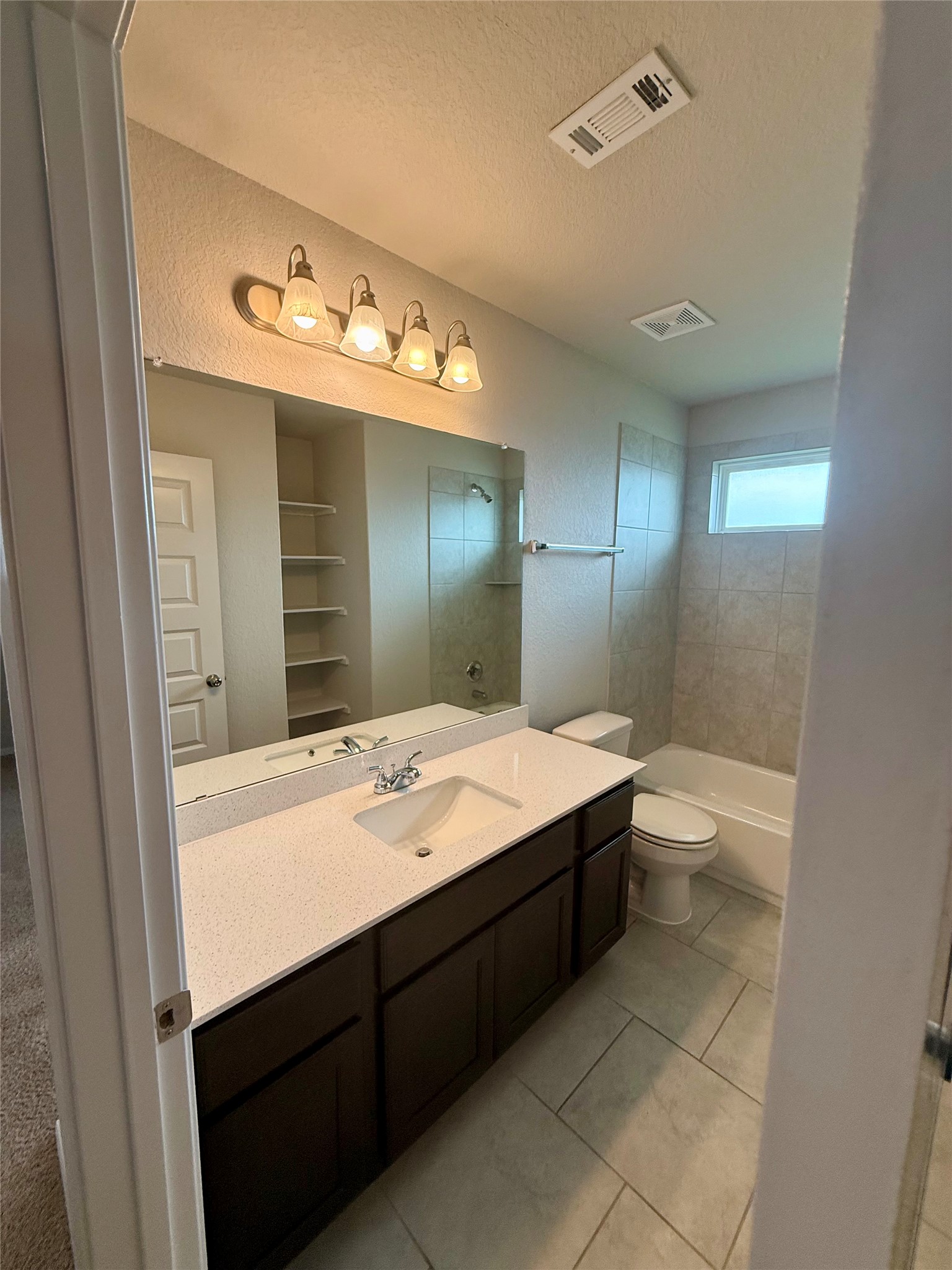 212 Lake Placid Run Elgin, TX 78621 - Photo 21 of 27 Well-lit vanity with ample counter space and a clean, tiled bathing area.