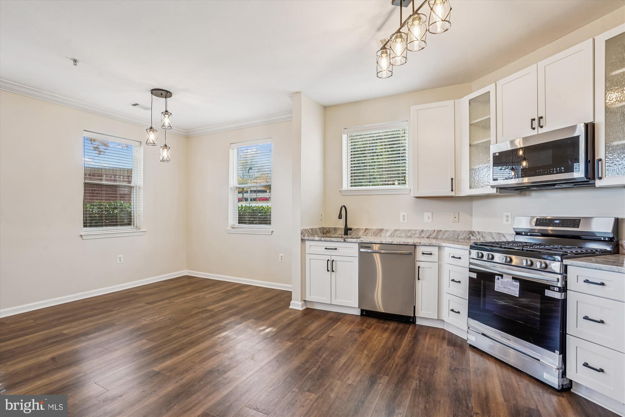9490 Virginia Center Boulevard, Unit 130 Vienna, VA 22181 - Photo 10 of 57 a kitchen with granite countertop wooden floor stainless steel appliances and white cabinets
