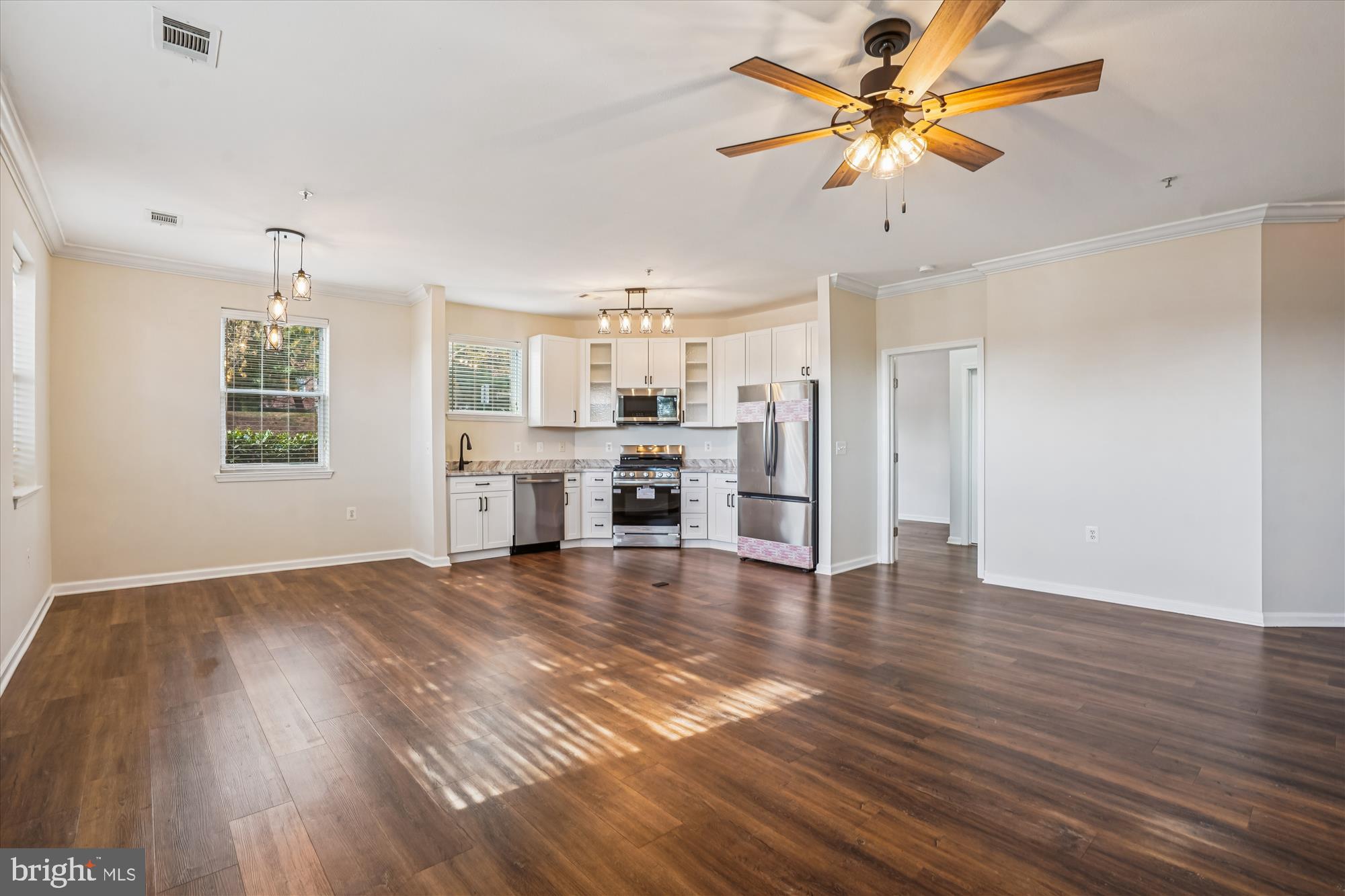 9490 Virginia Center Boulevard, Unit 130 Vienna, VA 22181 - Photo 55 of 57 a view of a kitchen with a stove cabinets a ceiling fan and wooden floor