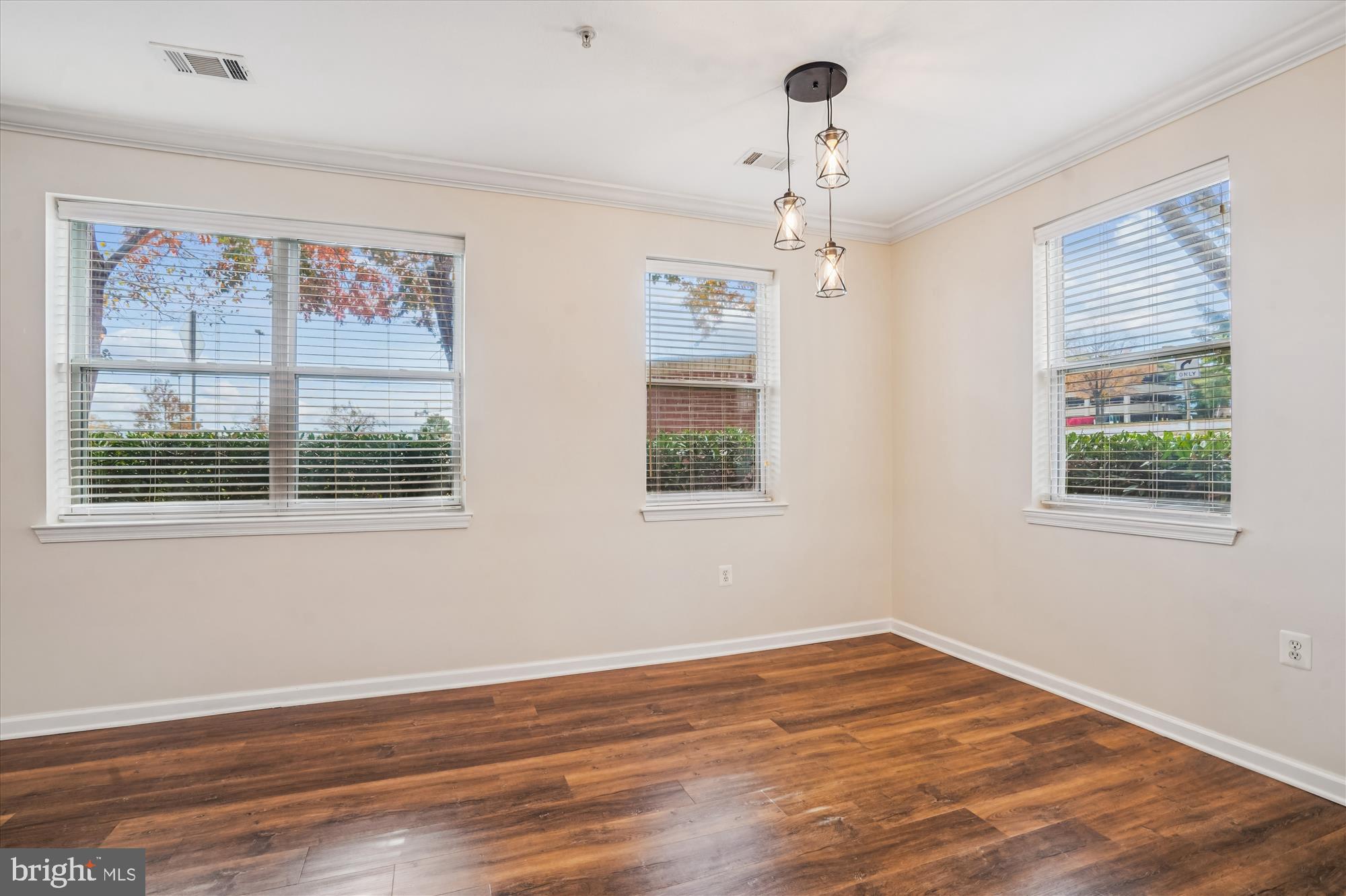 9490 Virginia Center Boulevard, Unit 130 Vienna, VA 22181 - Photo 7 of 57 a view of an empty room with wooden floor and a window
