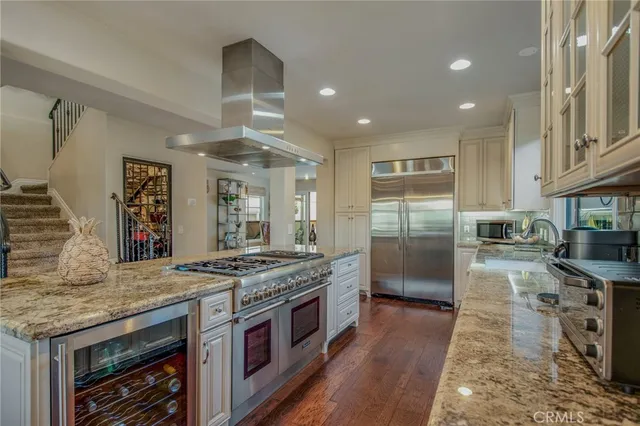 a kitchen with stainless steel appliances granite countertop a stove sink and cabinets