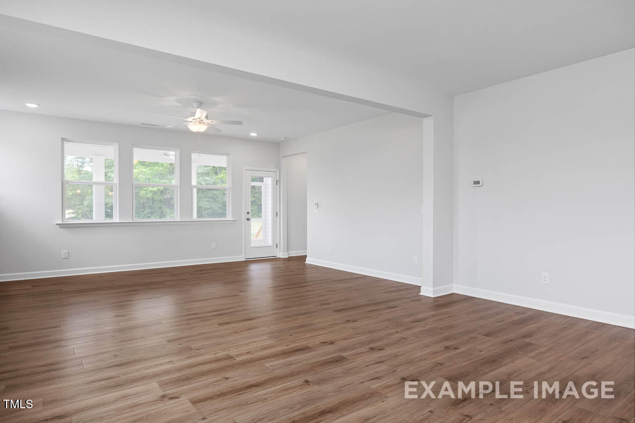 271 Crop Road Angier, NC 27501 - Photo 13 of 28 an empty room with wooden floor and windows
