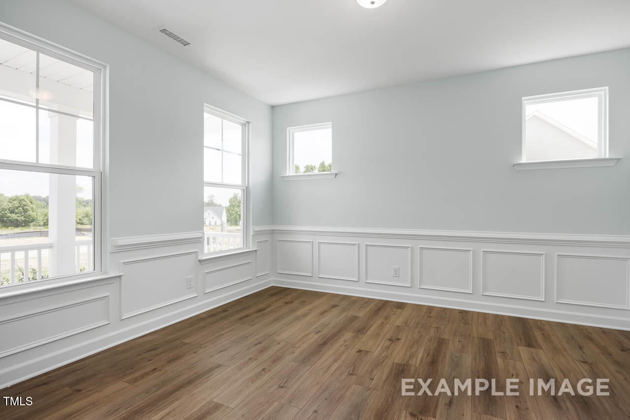 271 Crop Road Angier, NC 27501 - Photo 5 of 28 an empty room with wooden floor and windows