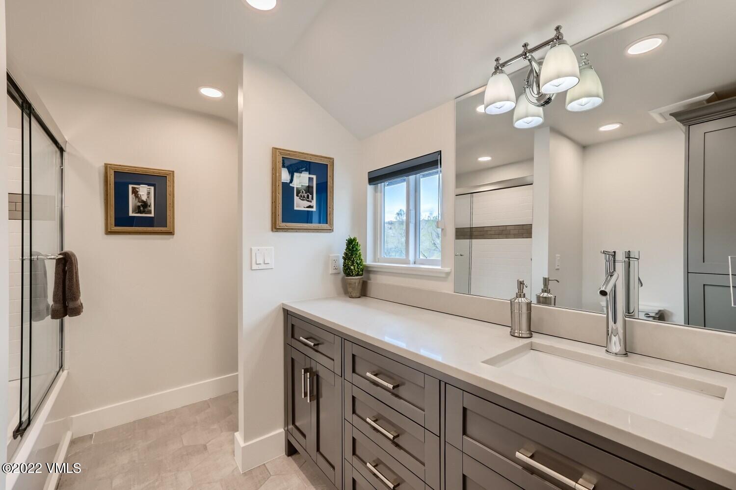 306 Howard Street Eagle, CO 81631 - Photo 23 of 30 a bathroom with a sink a large mirror and a light fixture