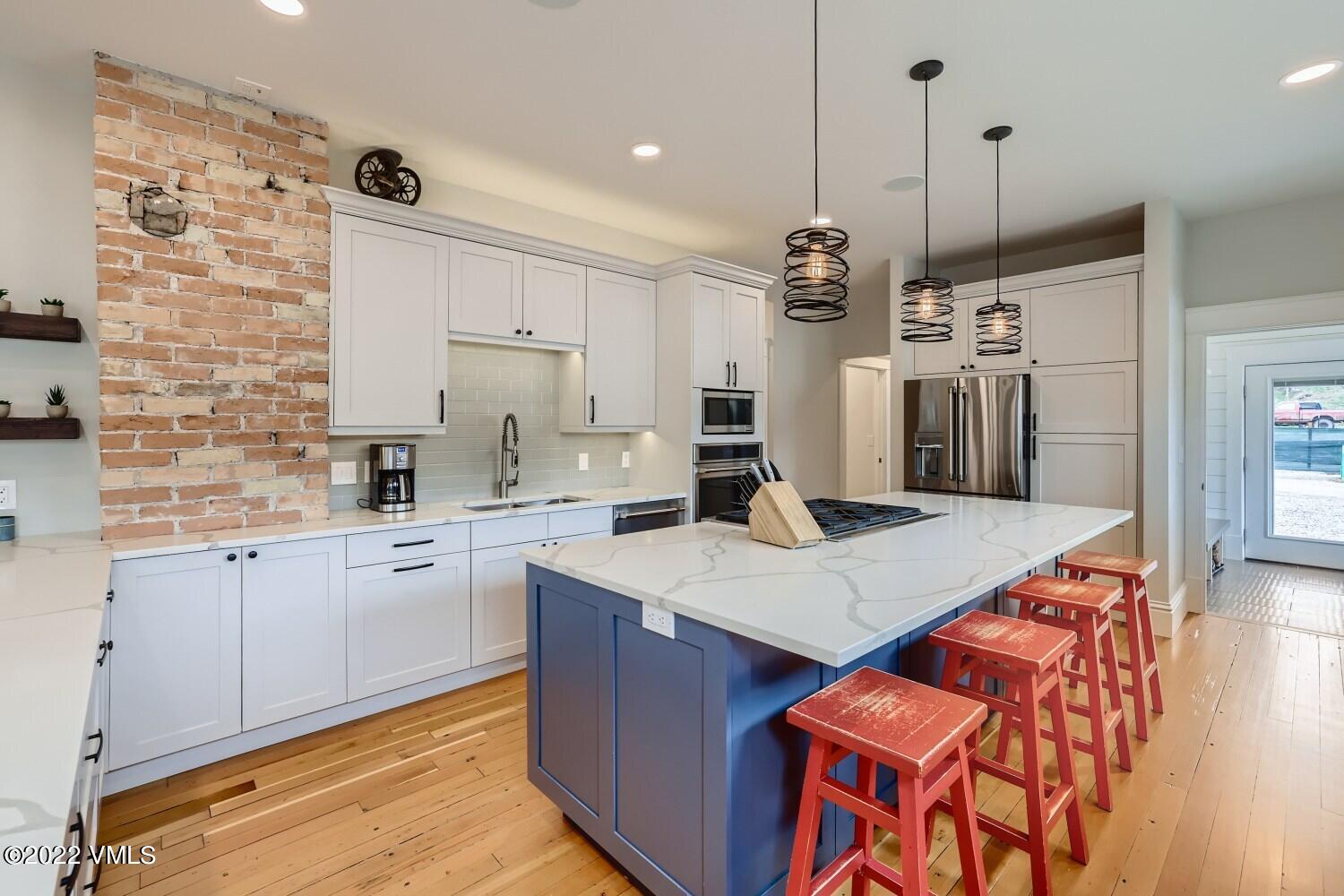 306 Howard Street Eagle, CO 81631 - Photo 9 of 30 a large kitchen with kitchen island a sink stove and refrigerator