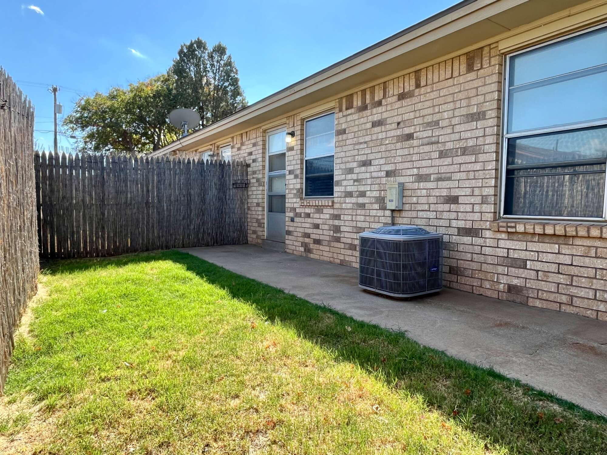 2308 74th Street, Unit A2 Lubbock, TX 79423 - Photo 15 of 16 a view of backyard with table and chairs and wooden fence