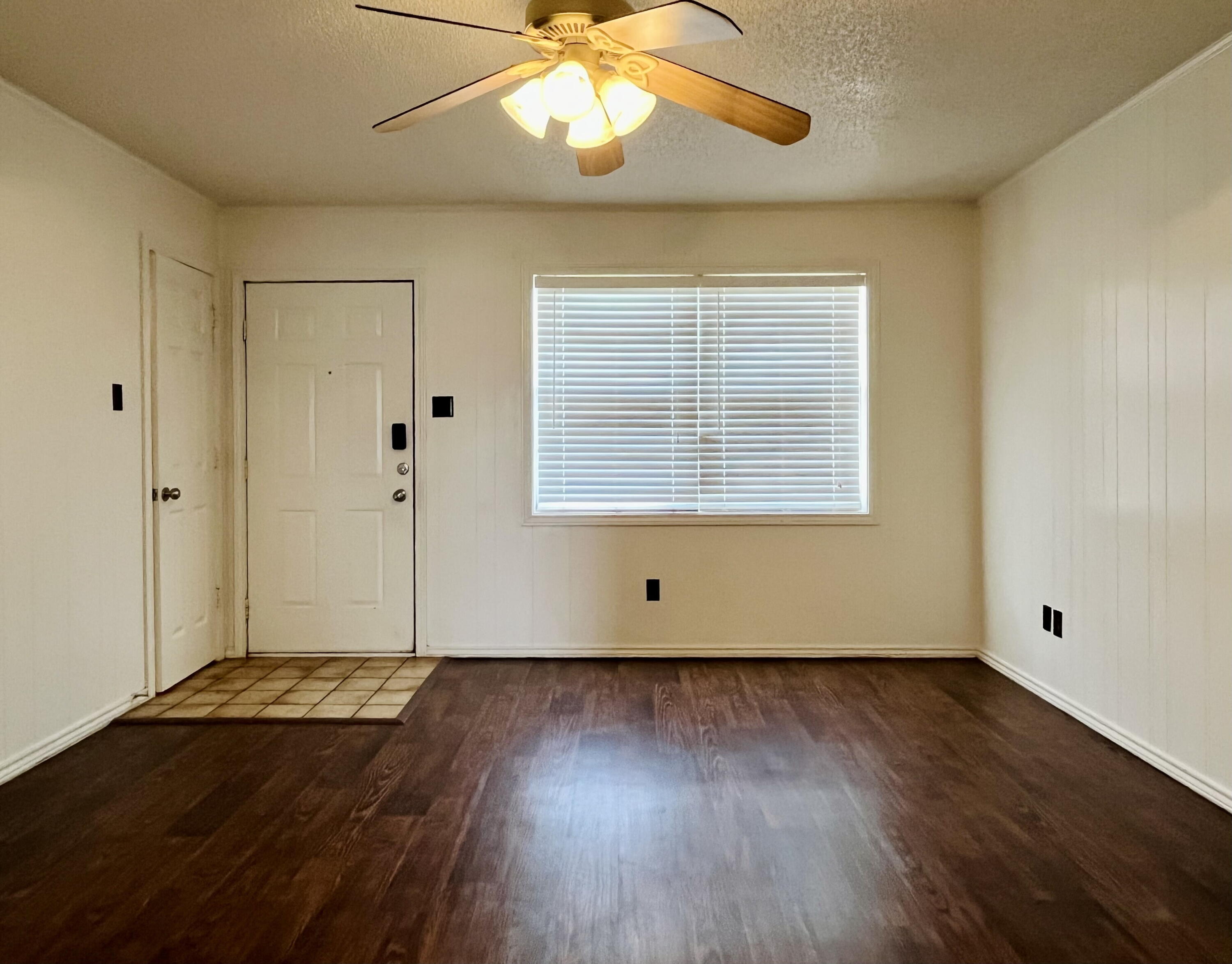 2308 74th Street, Unit A2 Lubbock, TX 79423 - Photo 4 of 16 a view of an empty room with wooden floor and a window