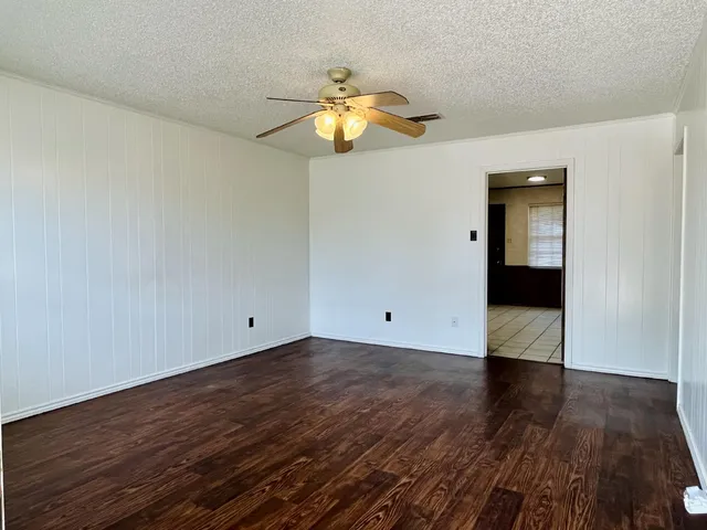 a view of empty room with wooden floor