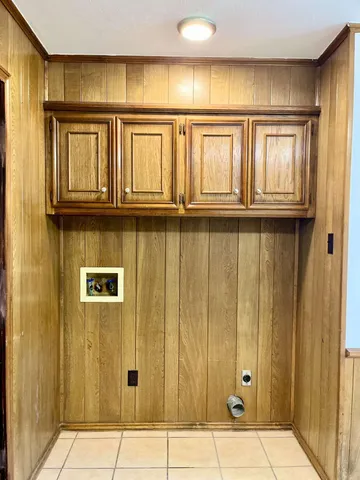 an empty room with a window and a chandelier fan