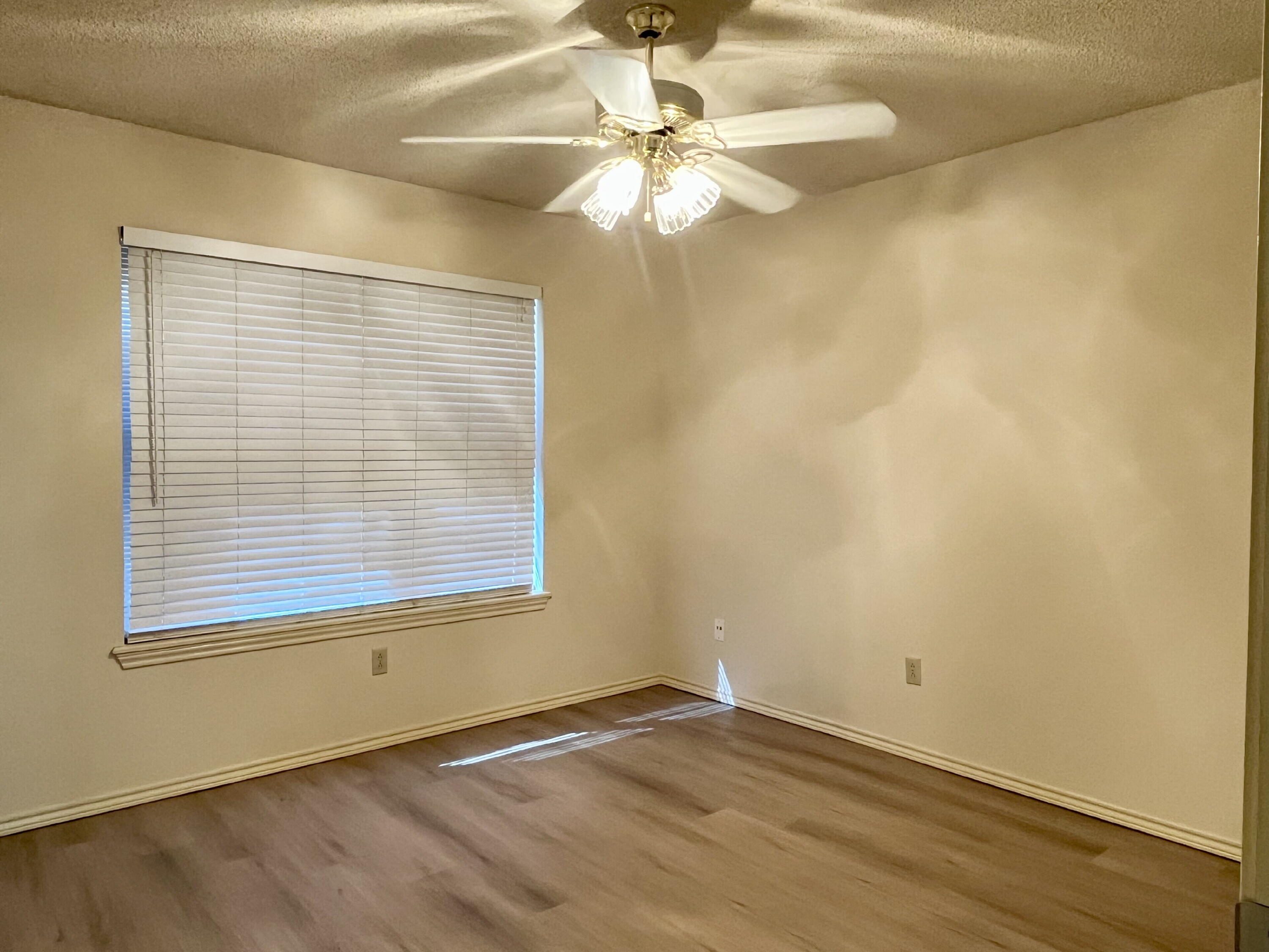 2308 74th Street, Unit A2 Lubbock, TX 79423 - Photo 10 of 16 an empty room with a window and a chandelier fan