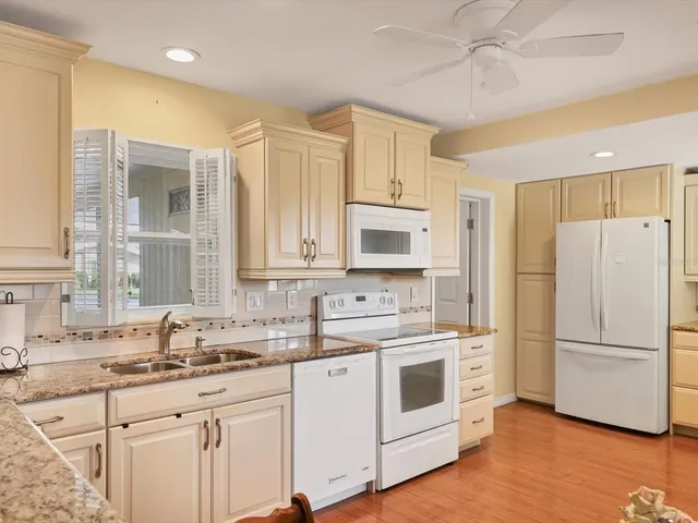 a kitchen with white cabinets and white appliances