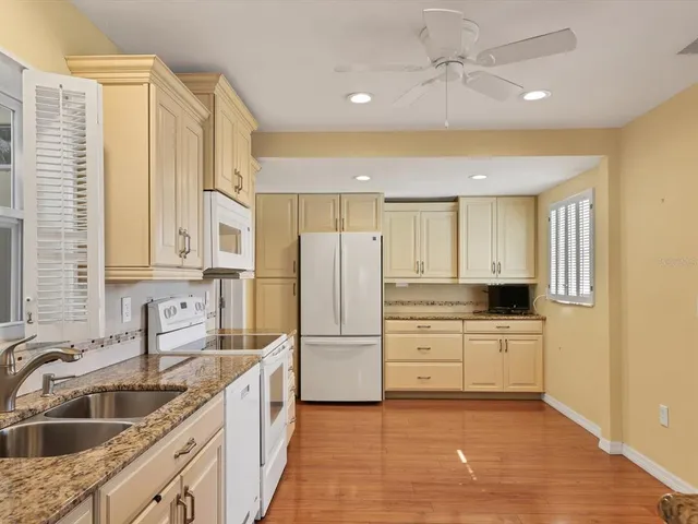 a kitchen with white cabinets and refrigerator