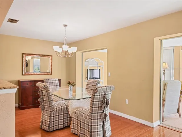 a dining room with furniture a chandelier and wooden floor