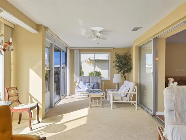 a living room with furniture a chandelier and a dining table