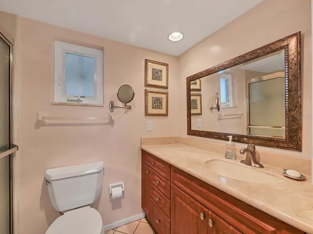a bathroom with a granite countertop toilet sink and mirror