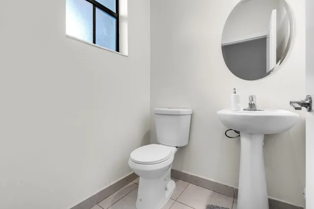 a bathroom with a toilet sink and mirror
