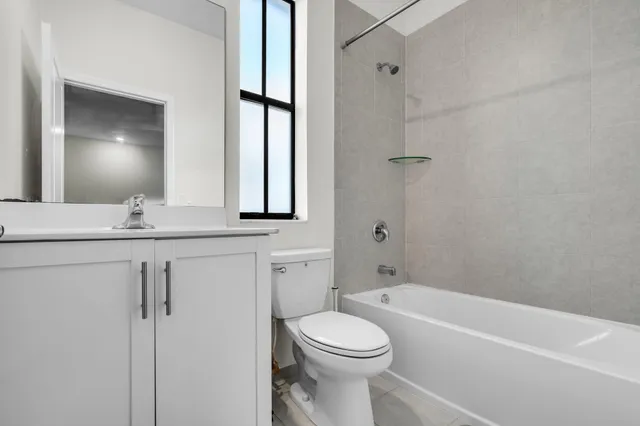 a bathroom with a toilet a sink a mirror a bathtub and shower