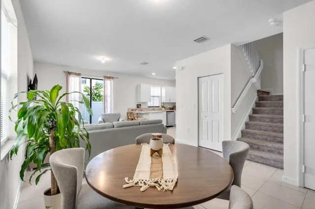 a dining room with furniture a potted plant and wooden floor