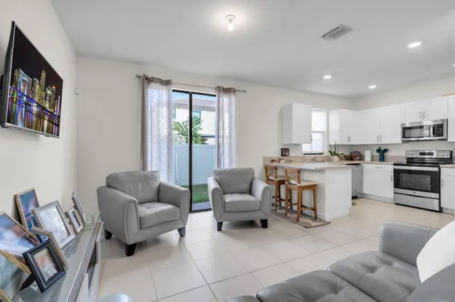 a living room with furniture and a open kitchen view