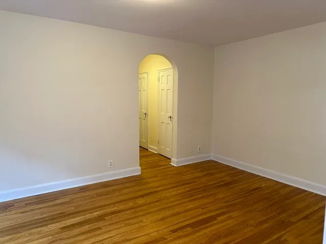 a view of a room with wooden floor and window