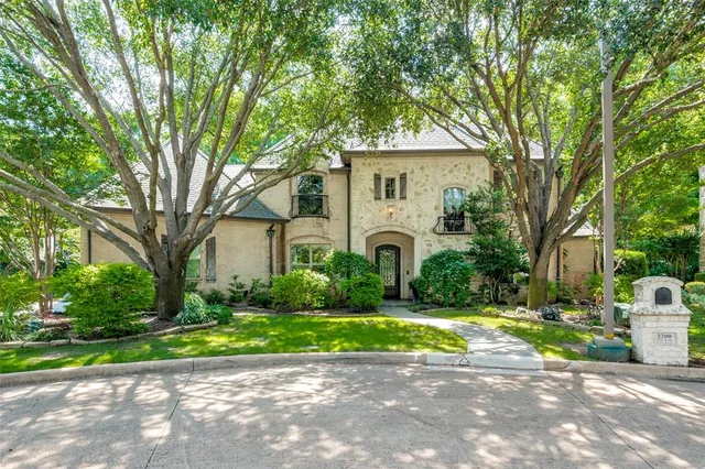 a view of a house with a big yard plants and large trees
