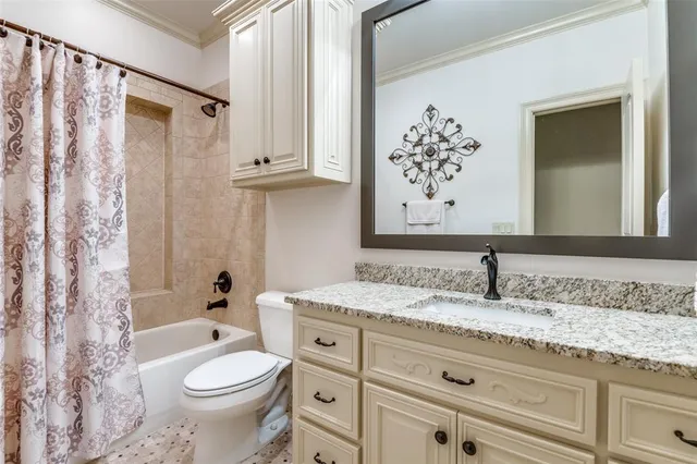 a bathroom with a granite countertop sink toilet mirror vanity and bathtub