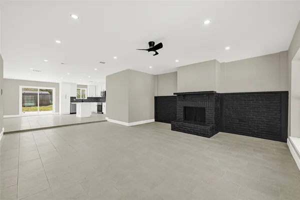 a view of an empty room with a fireplace and a window