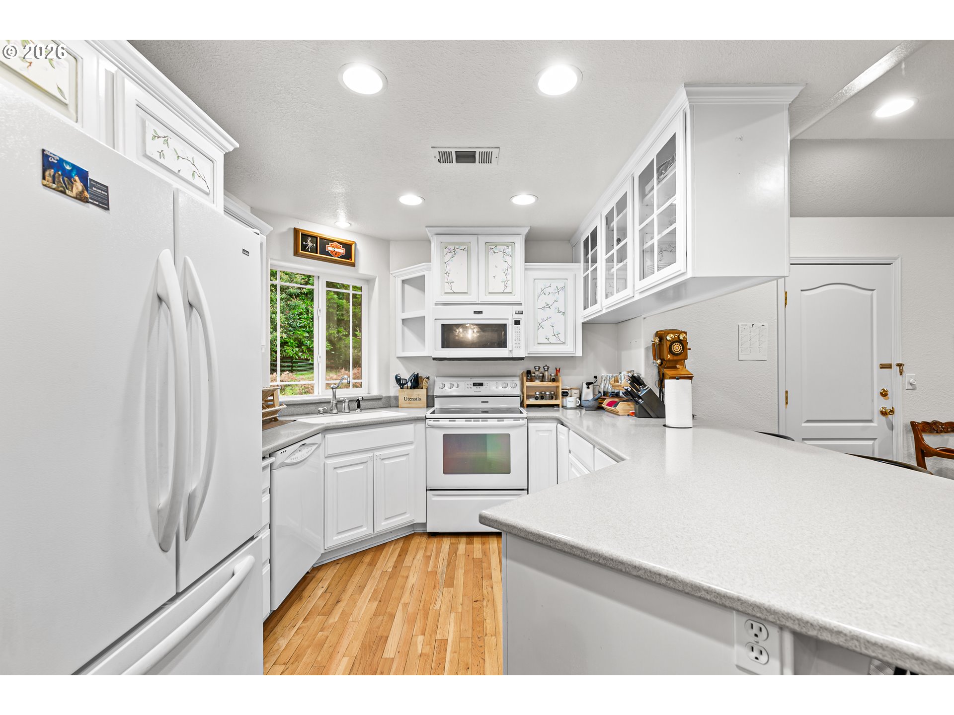 419 Idlewild Drive Cave Junction, OR 97523 - Photo 18 of 47 a kitchen with stainless steel appliances granite countertop a refrigerator a sink dishwasher a stove with white cabinets and wooden floor