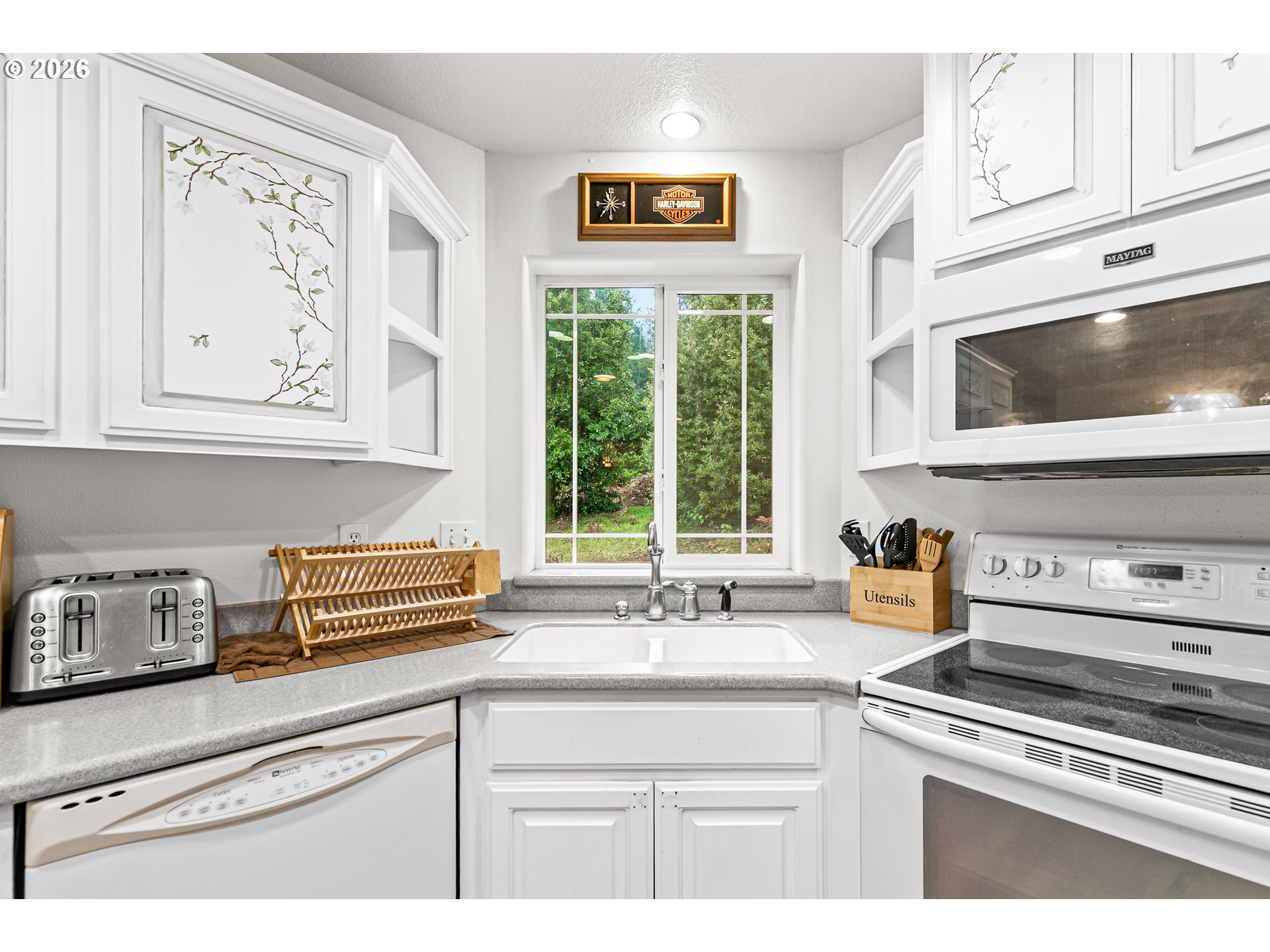 419 Idlewild Drive Cave Junction, OR 97523 - Photo 20 of 47 a kitchen with stainless steel appliances white cabinets and a window