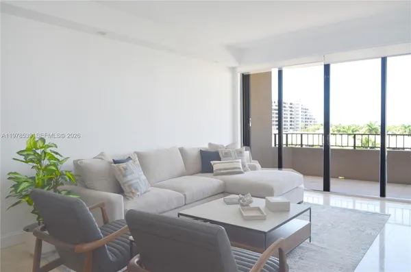 a living room with furniture and a floor to ceiling window