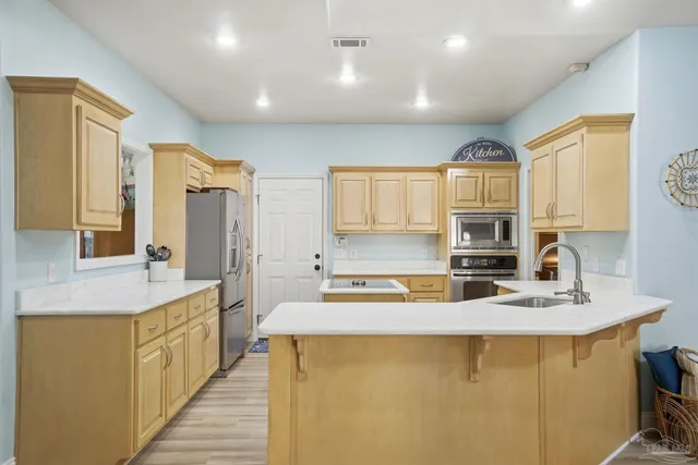 a kitchen with kitchen island granite countertop a sink a stove cabinets counter space and a window