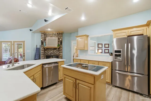 a kitchen that has a lot of cabinets a sink and appliances in it