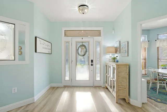 a view of a hallway with entryway dining room and wooden floor
