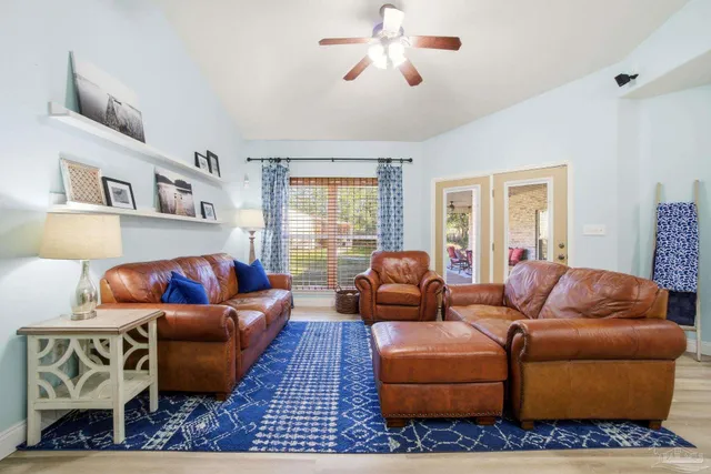 a living room with furniture ceiling fan and a window