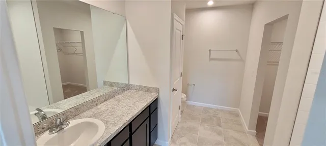 a bathroom with a granite countertop sink a mirror and a shower