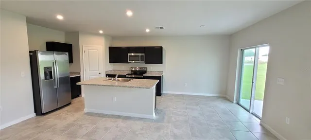 a view of kitchen with stainless steel appliances a refrigerator and a stove top oven