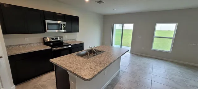 a kitchen with a sink microwave and cabinets
