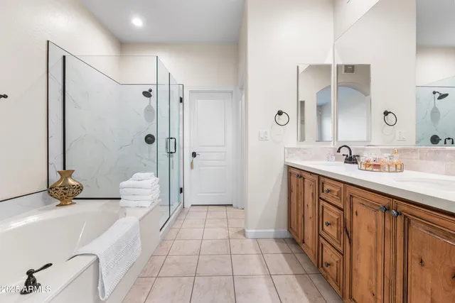 a spacious bathroom with a double vanity sink a mirror and a shower