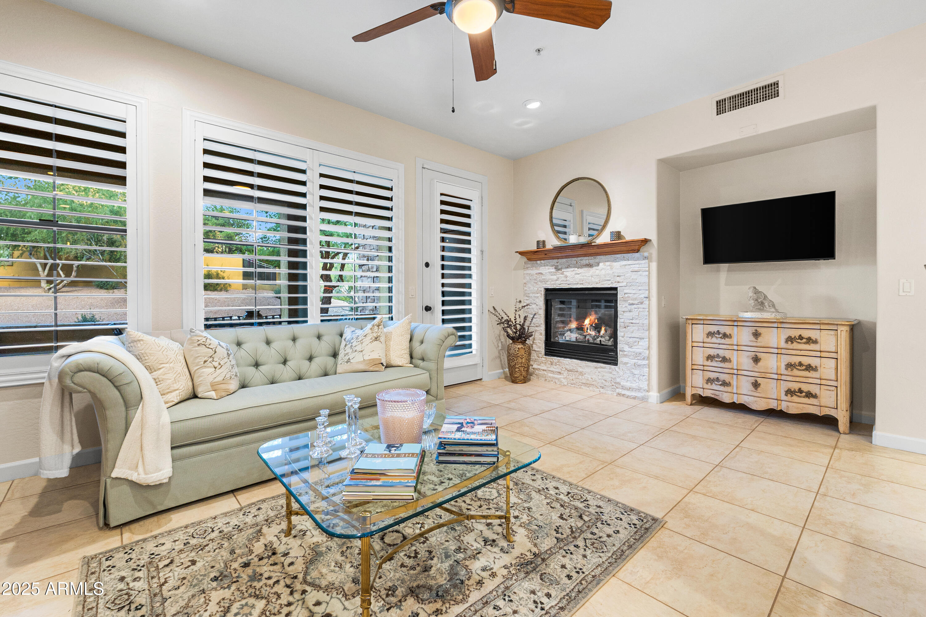 20750 North 87th Street, Unit 1050 Scottsdale, AZ 85255 - Photo 4 of 21 a living room with furniture a flat screen tv and a fireplace