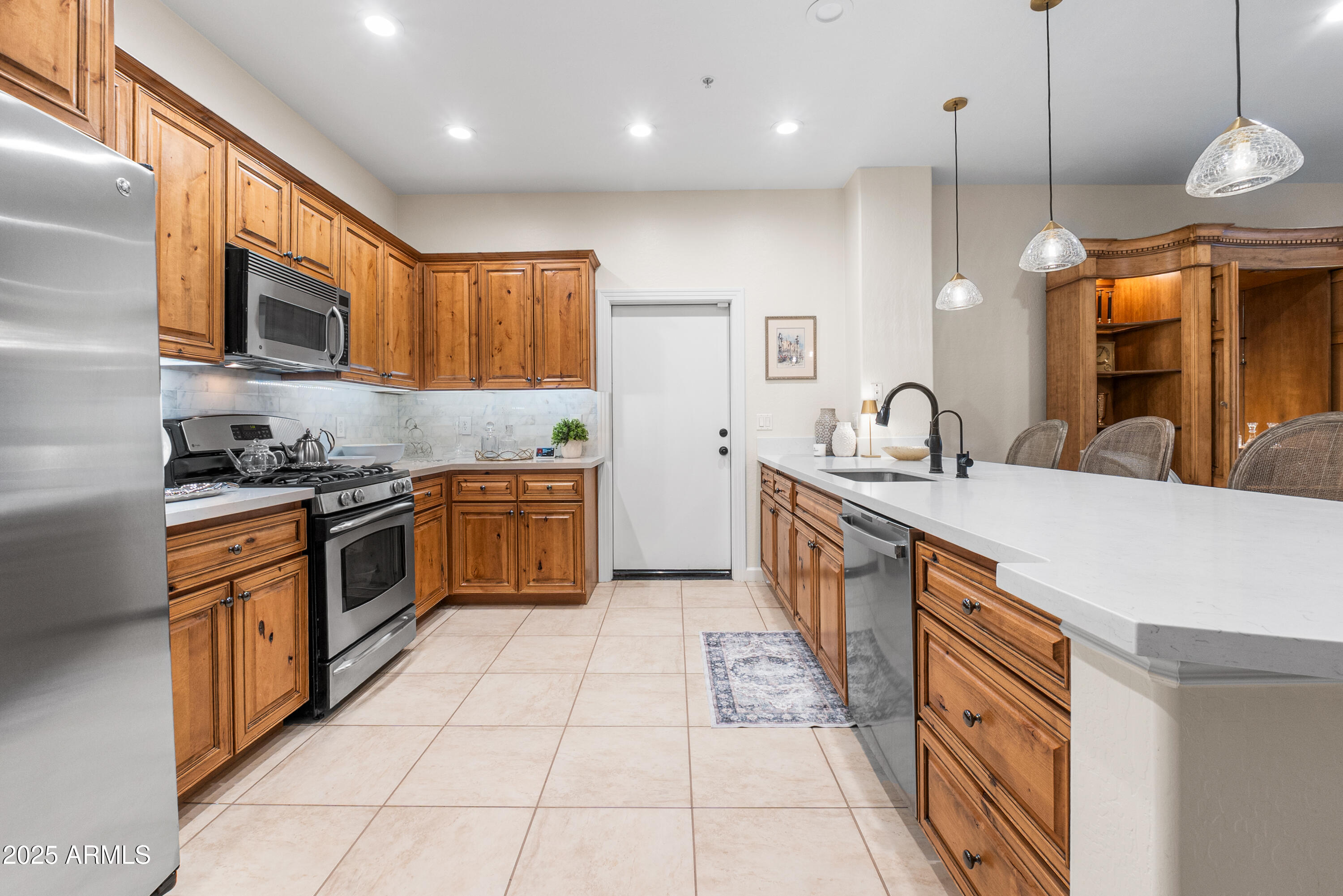 20750 North 87th Street, Unit 1050 Scottsdale, AZ 85255 - Photo 8 of 21 a kitchen with stainless steel appliances a sink a stove top oven a counter space and cabinets
