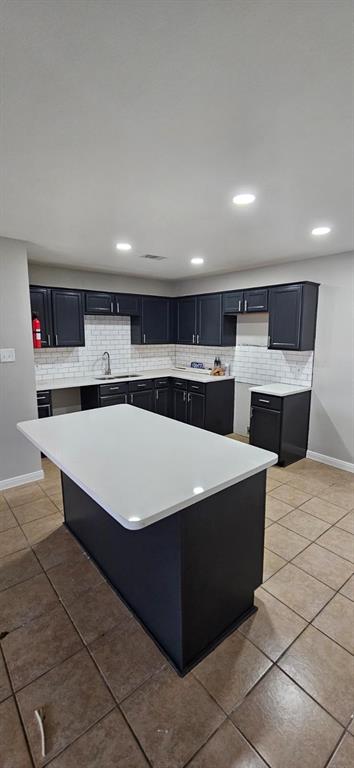 a large kitchen with kitchen island a sink a stove and a refrigerator