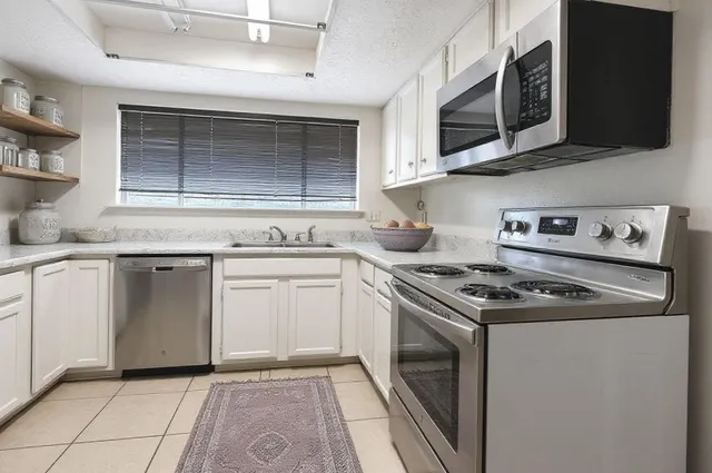 a kitchen with stainless steel appliances granite countertop a stove and a microwave