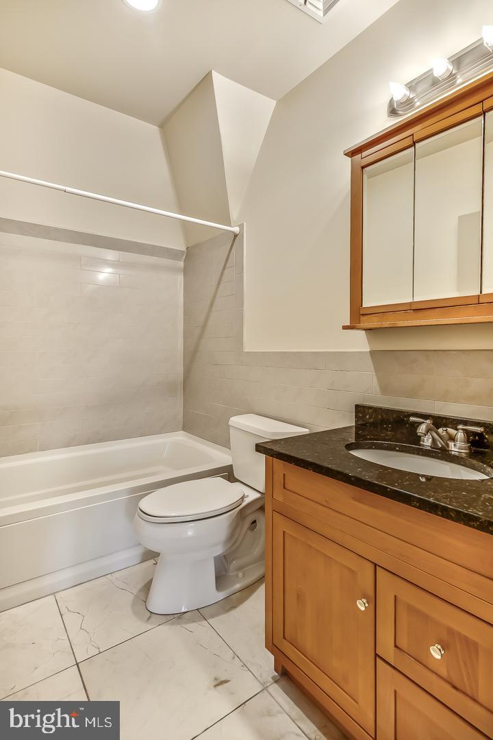 4200 Pine Street, Unit 108A Philadelphia, PA 19104 - Photo 43 of 49 a bathroom with a granite countertop toilet sink and mirror