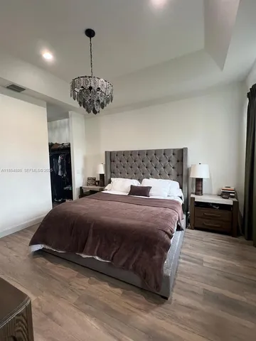 a bedroom with a bed and a chandelier