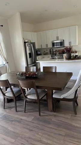 a kitchen with a table chairs a sink dishwasher and cabinets