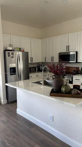 a kitchen with stainless steel appliances granite countertop a refrigerator a stove a sink and a microwave