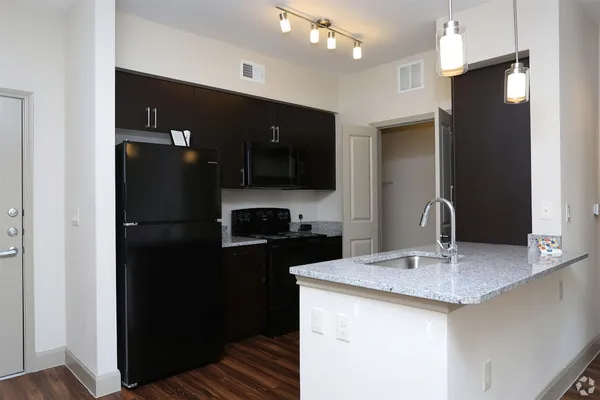 a kitchen with a sink a refrigerator and cabinets